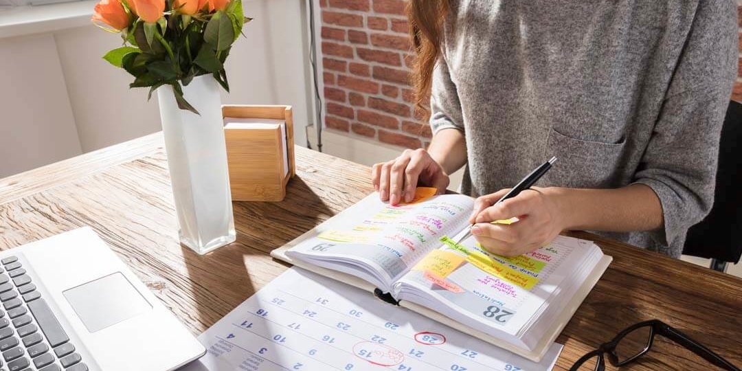 woman writing plan on calendar