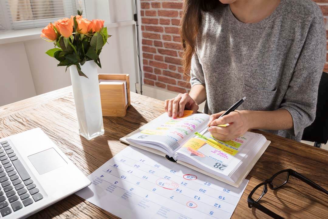 woman writing plan on calendar